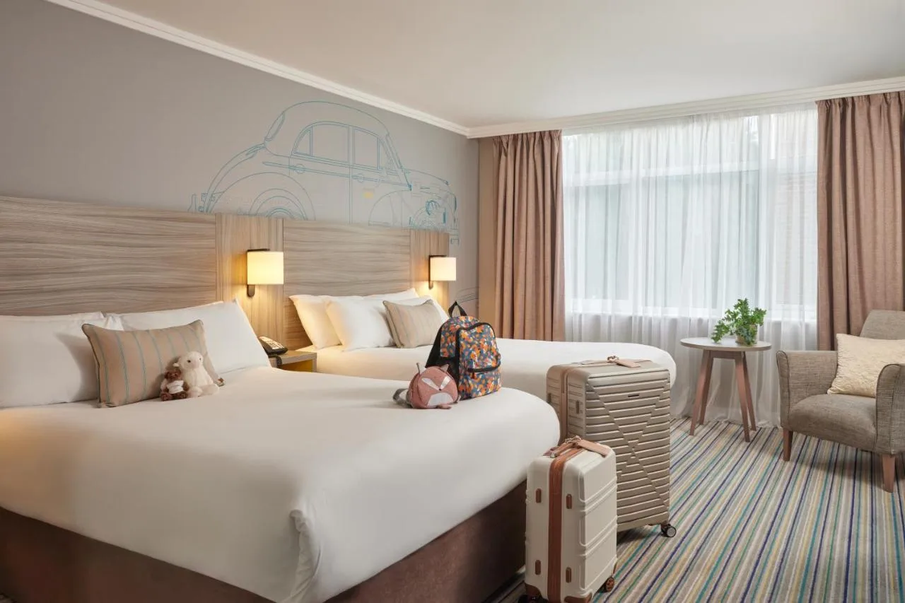 a hotel room with a large bed and a chair at Leonardo Royal Hotel Oxford in Oxford