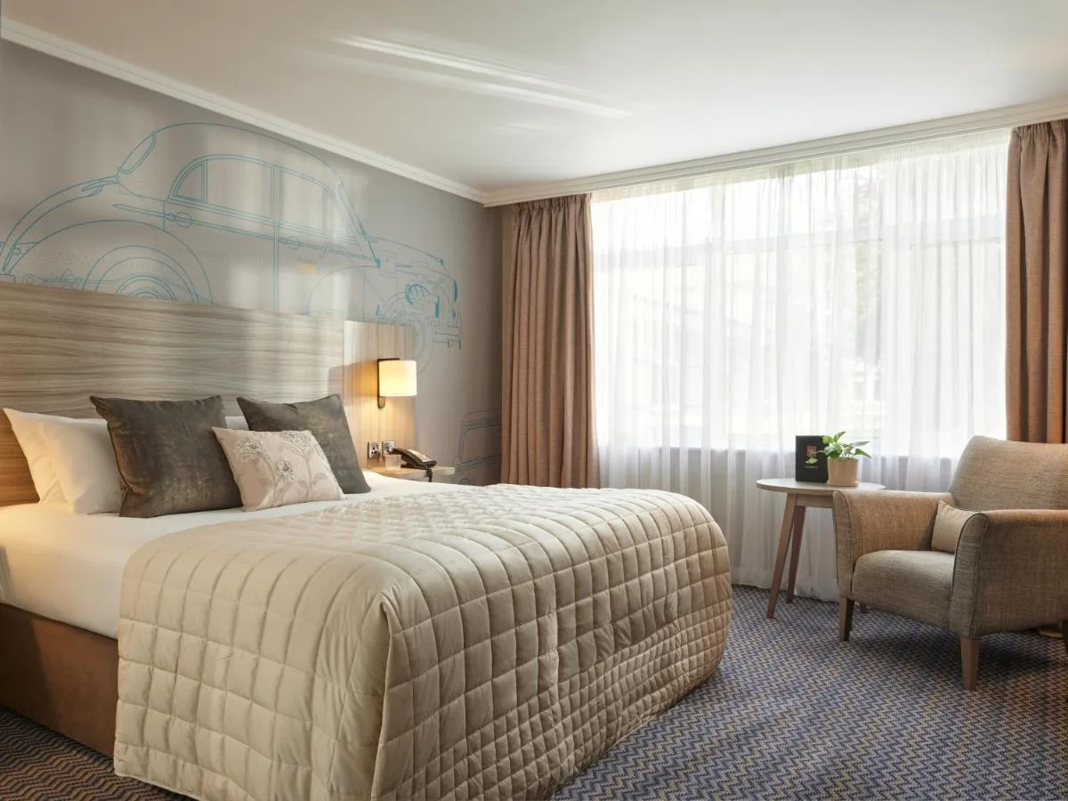 a hotel room with a bed and a chair at Leonardo Royal Hotel Oxford in Oxford