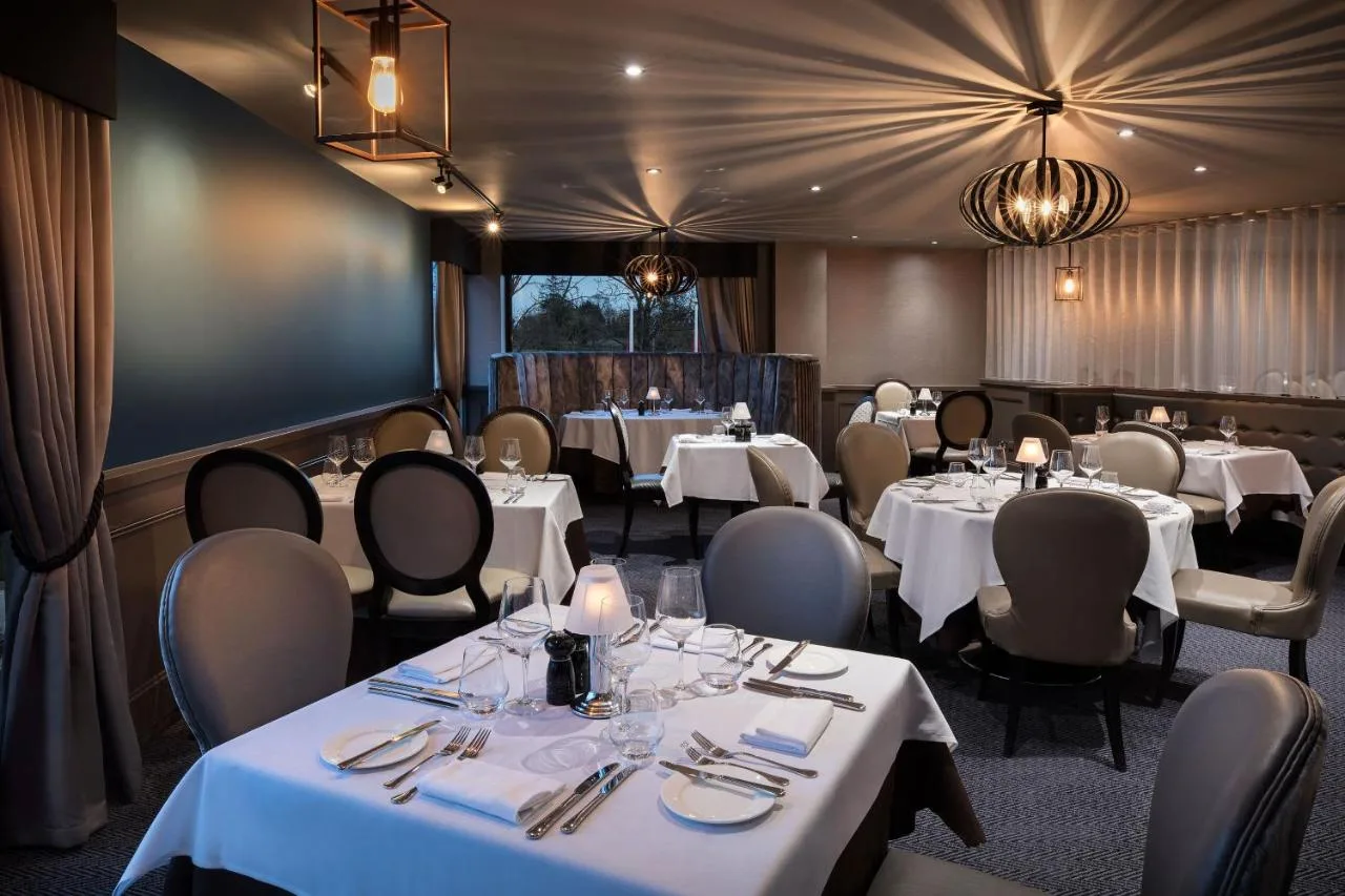 a dining room with white tables and chairs at Leonardo Royal Hotel Oxford in Oxford